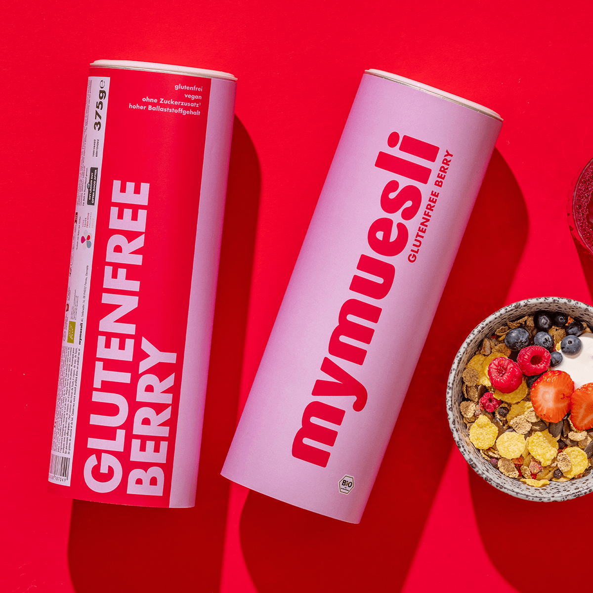 mymuesli Bio Glutenfree Berry Müsli Dosen und Schale mit frischen Beeren und Joghurt