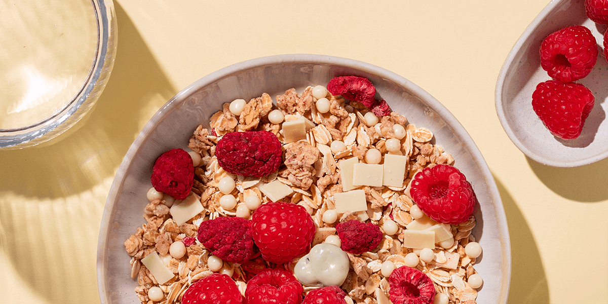 mymuesli Bio Berry White Choc Müsli mit Kaffee und frischen Himbeeren zum Frühstück