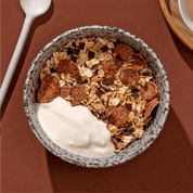 mymuesli Bio Low Sugar Choco Crunch in Schale mit Joghurt
