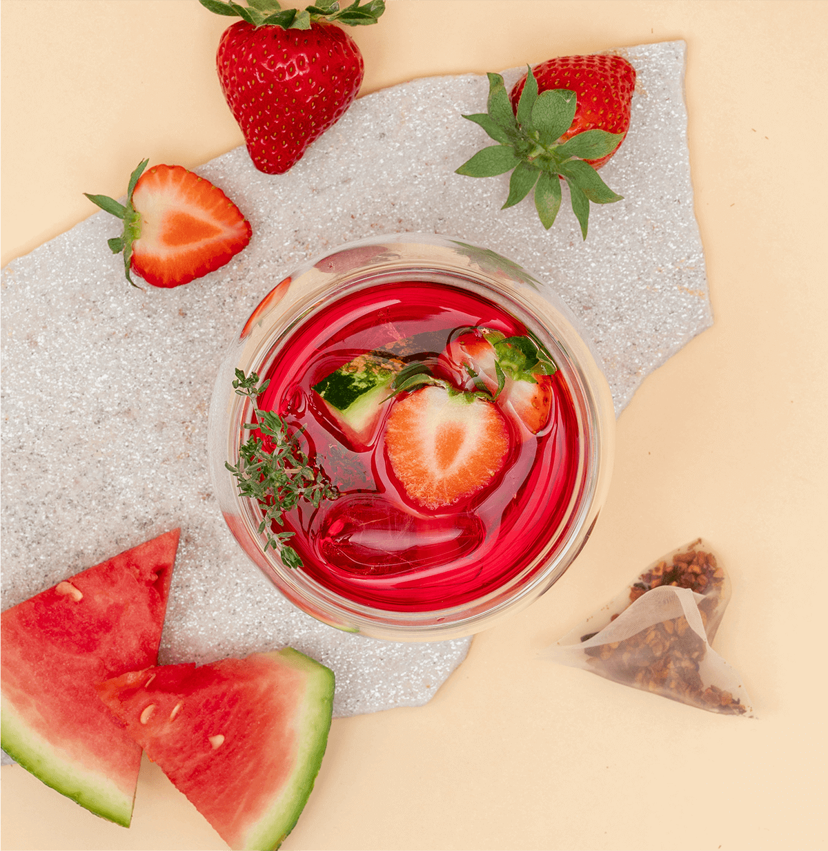 Tree of Tea Ice Tea Watermelon Strawberry in einem Glas mit Erdbeeren und Melone daneben