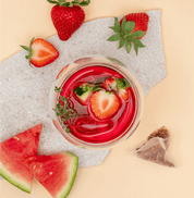 Tree of Tea Ice Tea Watermelon Strawberry in einem Glas mit Erdbeeren und Melone daneben
