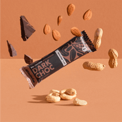 mymuesli Bio Protein Müsliriegel Dark Choc umgeben von Schokolade, Mandeln, Erdnüsse und Cashewkerne.