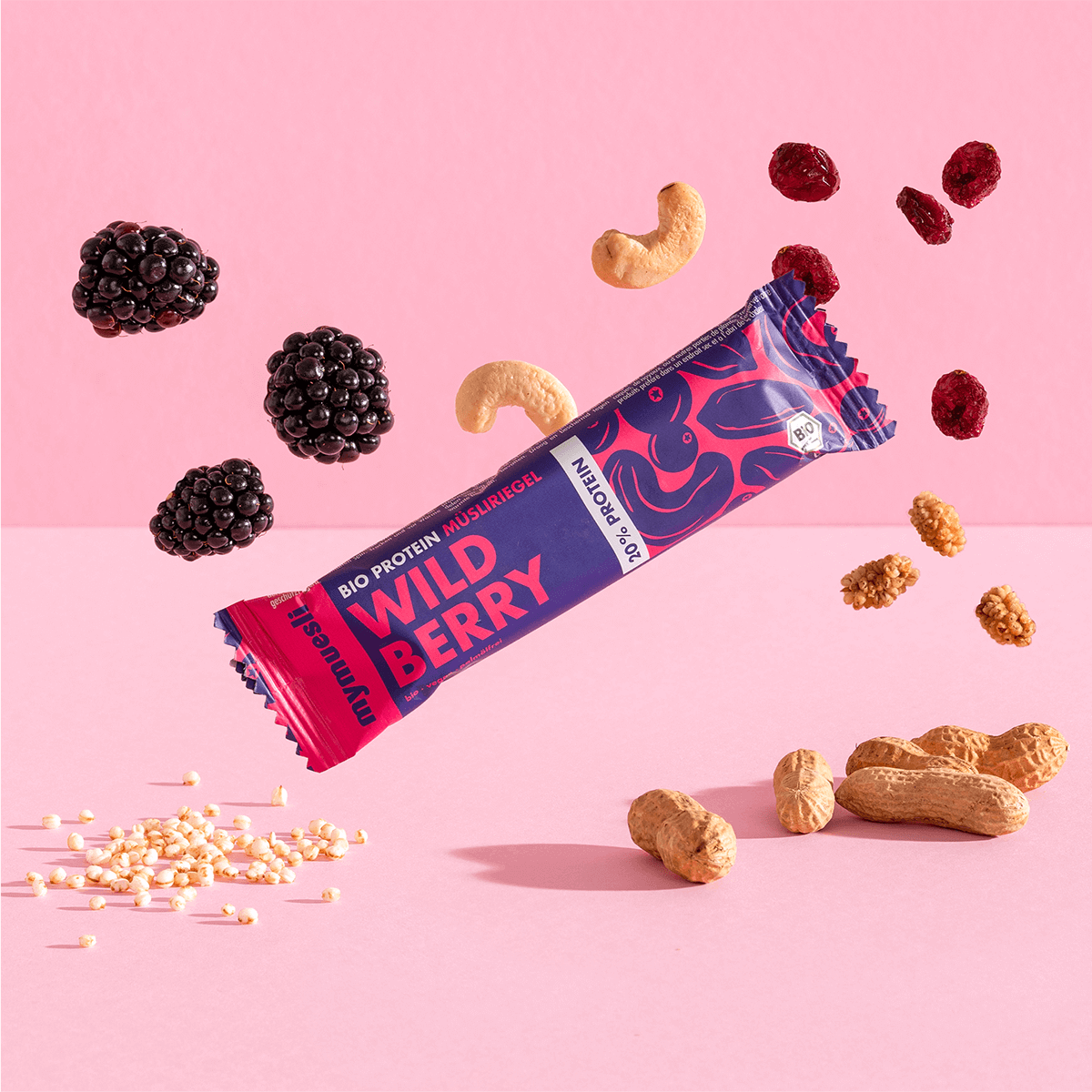 mymuesli Bio Protein Müsliriegel Wild Berry umgeben von frischen Maulbeeren, Cranberries, Knackige Reiscrispies, Cashewkerne und Mandeln