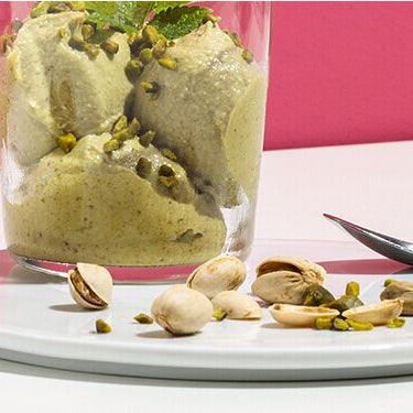 Avocado Pistazien Nicecream mit einer halben Avocado daneben