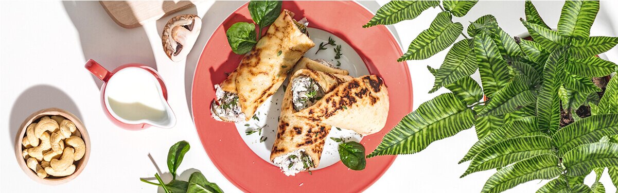 Herzhafte Pfannkuchen auf dem Teller mit einer Schale Cashews daneben