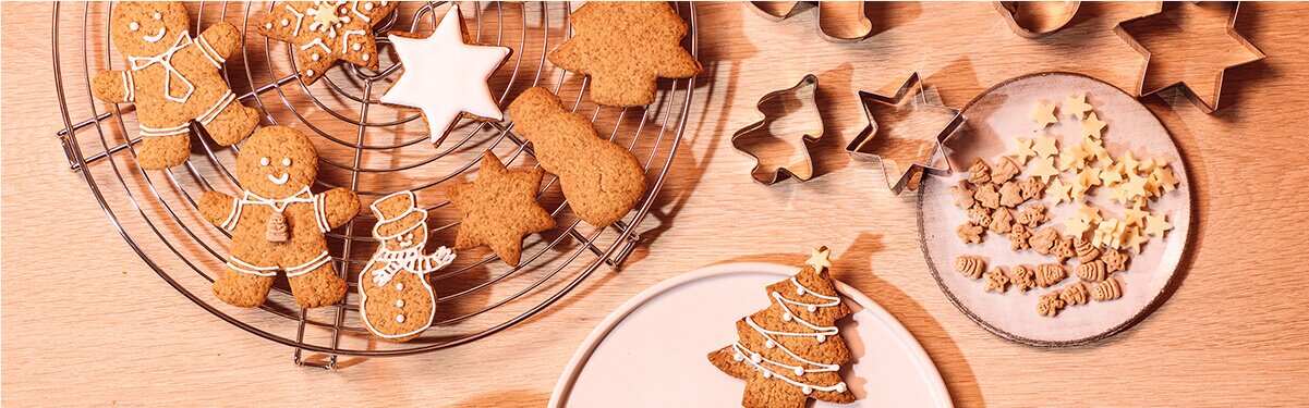 Christmas Cookies auf Tellern mit Ausstechförmchen daneben