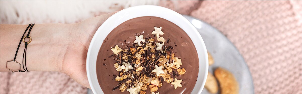 Selbstgemachter Schokoladenpudding in einer Schüssel mit Christmas-Granola