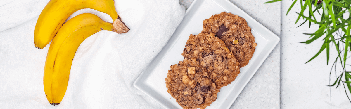 Cookies auf einem Teller und Bananen daneben