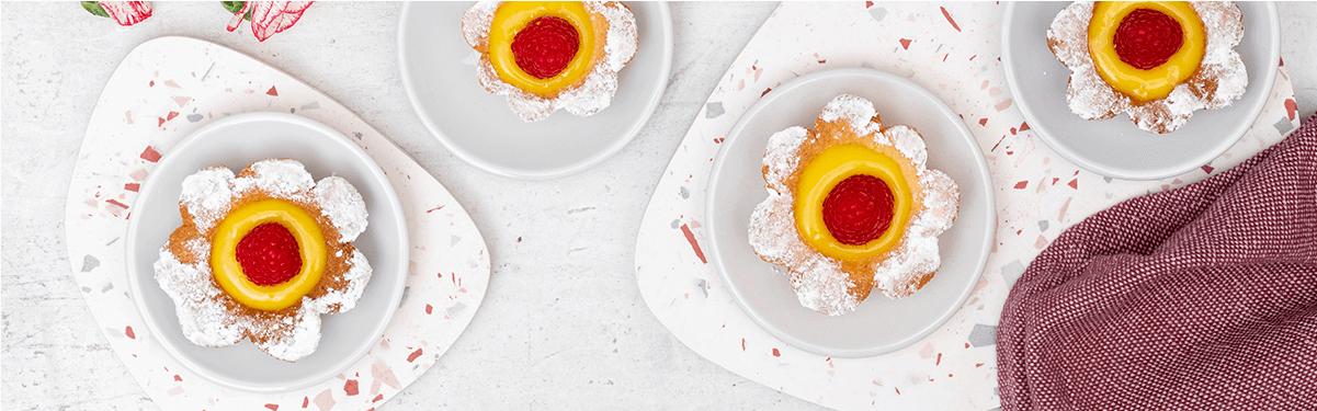Himbeer-Lemon Curd Blumen Tartes auf Tellern