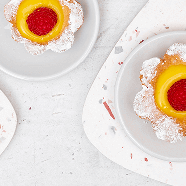 Himbeer-Lemon Curd Blumen Tartes auf Tellern