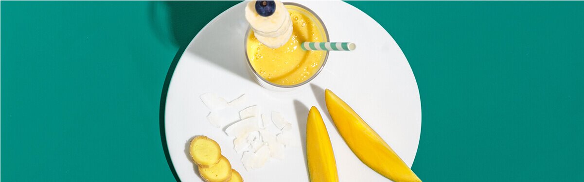 Bananen Smoothie mit einem Strohhalm auf einem Teller