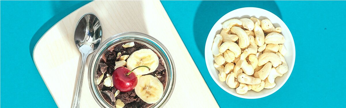 Schoko Bananen Nicecream mit einer Schale Cashews daneben