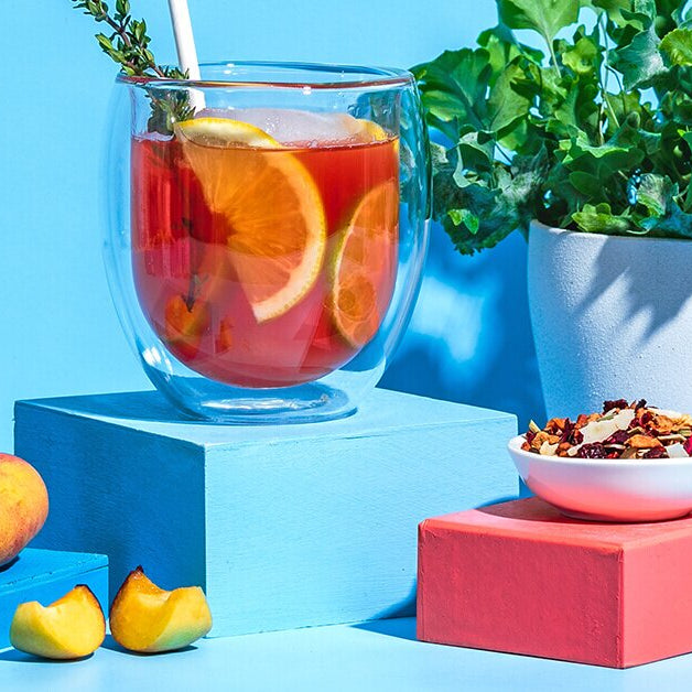 Peachy Ginger Lemonade mit Limettenscheiben und Thymian dekoriert