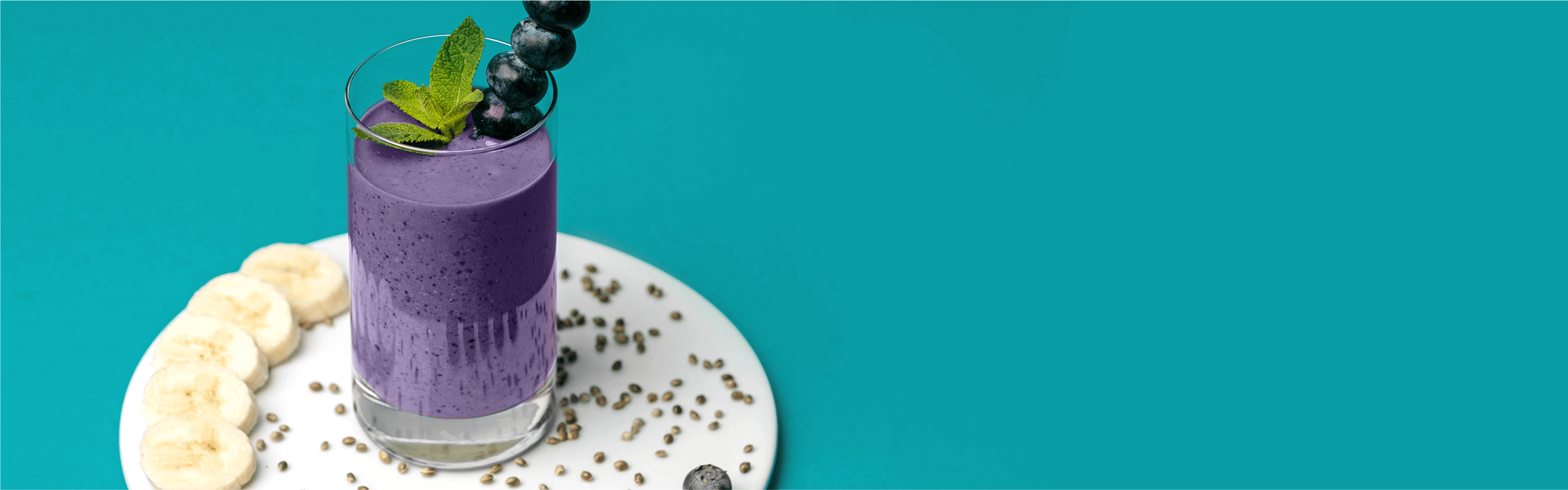 Protein Smoothie auf einem Teller mit Bananenscheiben dekoriert