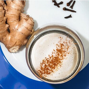 Pumpkin Spice Latte mit Zimtstangen und Ingwer dekoriert