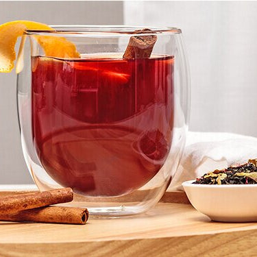 Winterpunsch im Glas mit Orangenschale dekoriert