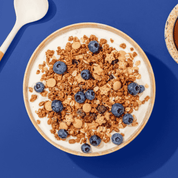 Bio Christmas Choco Apricot Crunch mit getrockneten Aprikosen,serviert mit frischen Blaubeeren und Joghurt. 