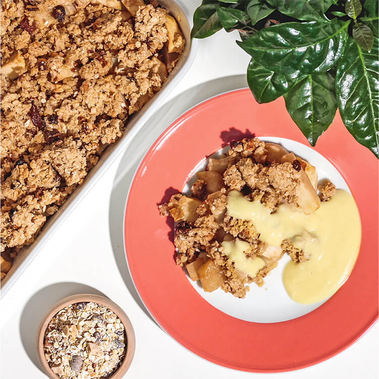 Apple Crumble auf einem Teller mit Vanillesauce