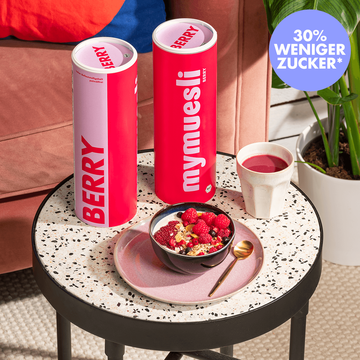 mymuesli Bio Berry Müsli - beeriges Müsli perfekt mit Joghurt und Chia-Jam in Schüssel auf Terazzotisch mit Berry Smoothie und Berry Müsli Dosen