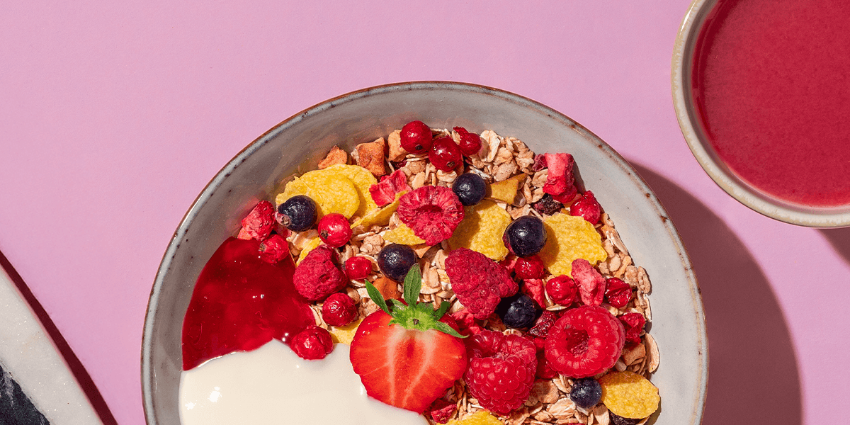 mymuesli Bio Berry Müsli mit Himbeeren, Blaubeeren, Johanisbeeren und Erdbeeren in Schüssel mit Joghurt