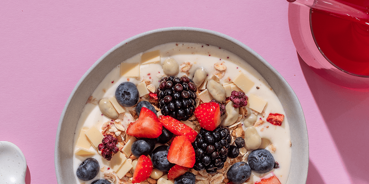 mymuesli Bio Wildberry Yoghurt Müsli mit leckeren firschen Brombeeren Blaubeeren und Erdbeeren in Schüssel mit Joghurt