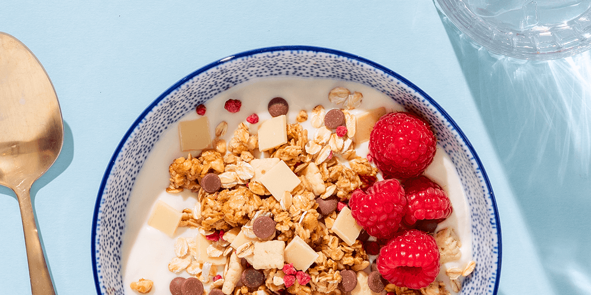 mymuesli Bio Raspberry Yoghurt Cookie Müsli in Schale mit Yoghrut und frischen Himbeeren