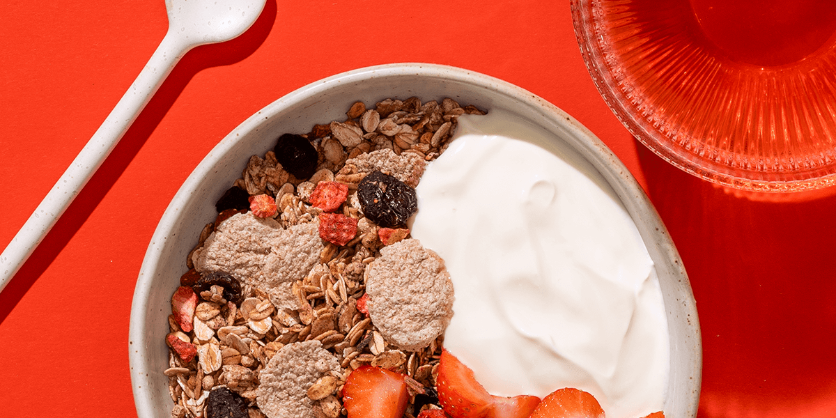 mymuesli Bio Strawberry Acai Granola serviert mit Joghurt und frischen Erdbeeren: das perfekte fruchtige Frühstück