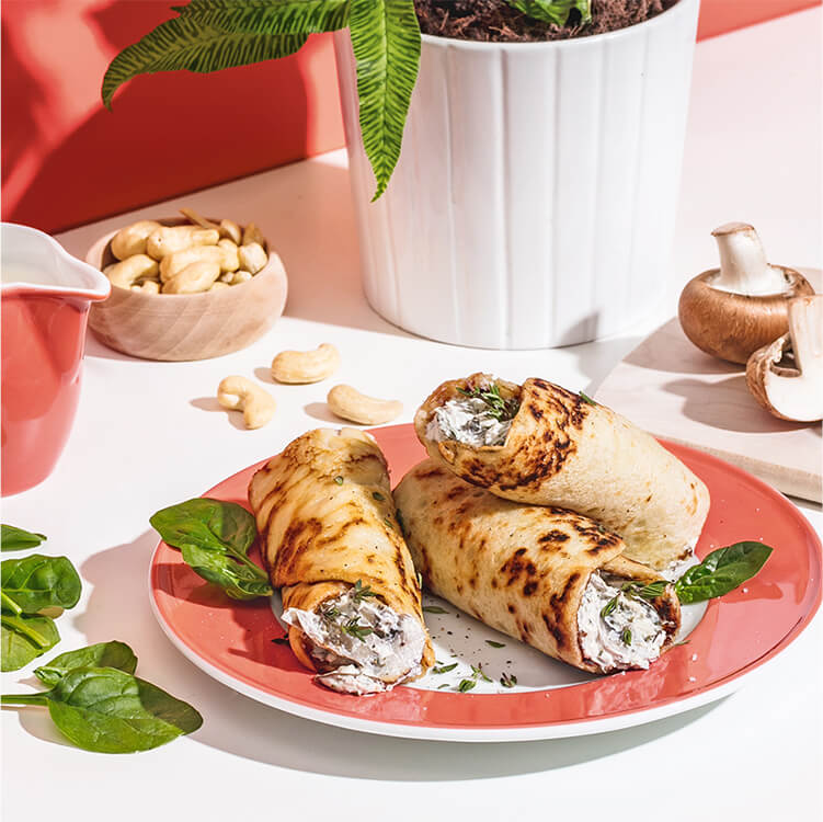 Herzhafte Pfannkuchen auf dem Teller mit einer Schale Cashews daneben