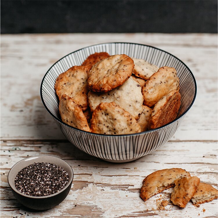 Knusprige Chia-Kekse in einer Schale mit einem Schälchen Chia Samen daneben