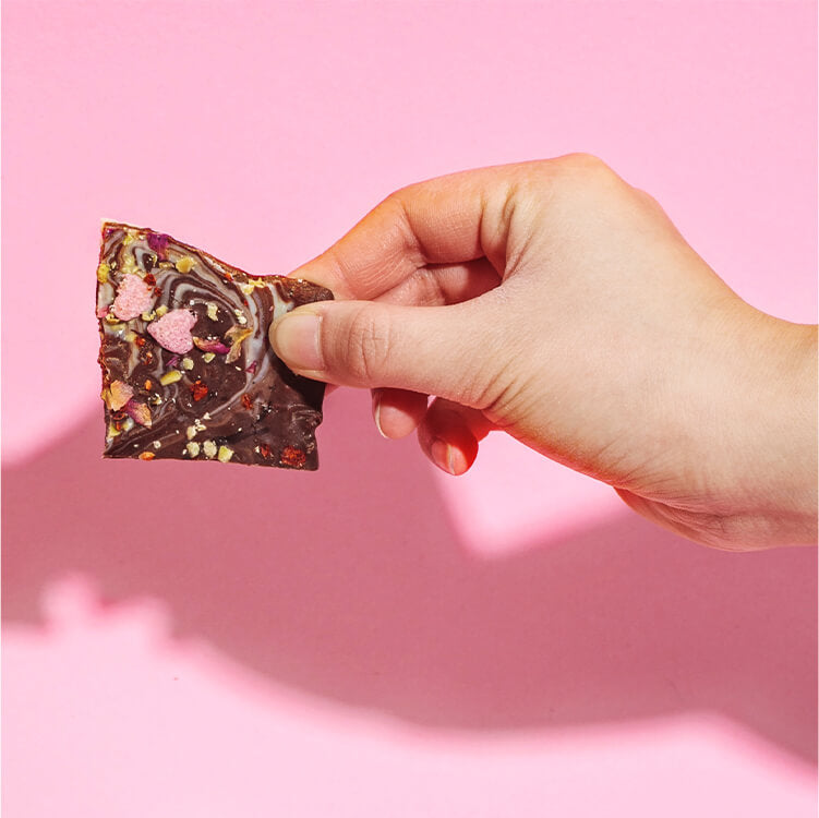 Bruchschokolade mit Toppings in der Hand