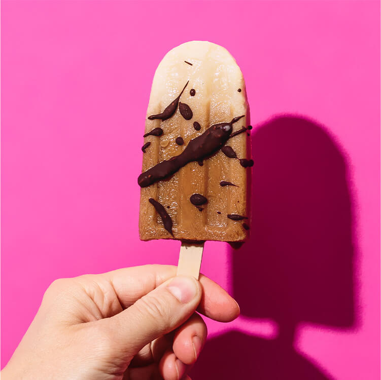 Popsicle-Eis Iced Coffee in einer Hand