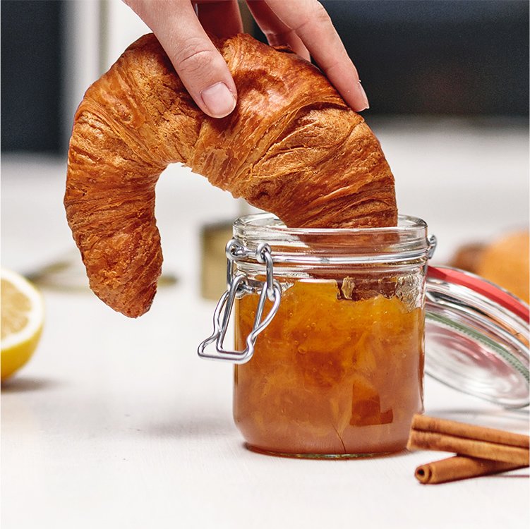 Ein Croissant wird in Rooibos Orangen Marmelade gedippt