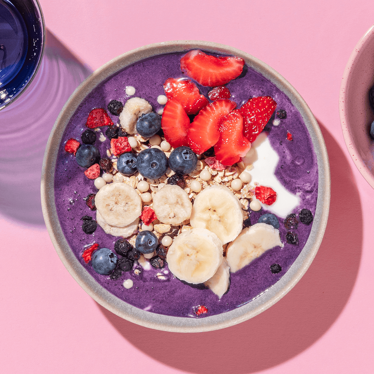 mymuesli Bio Blueberry Müsli zubereitet als leckere Smoothie Bowl aus Heidelbeeren mit frischen Beeren und Bananen als Topping
