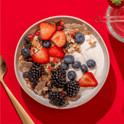 mymuesli Bio Blackberry Granola in Schale mit frischen Erdbeeren, Blaubeeren, Brombeeren und Joghurt