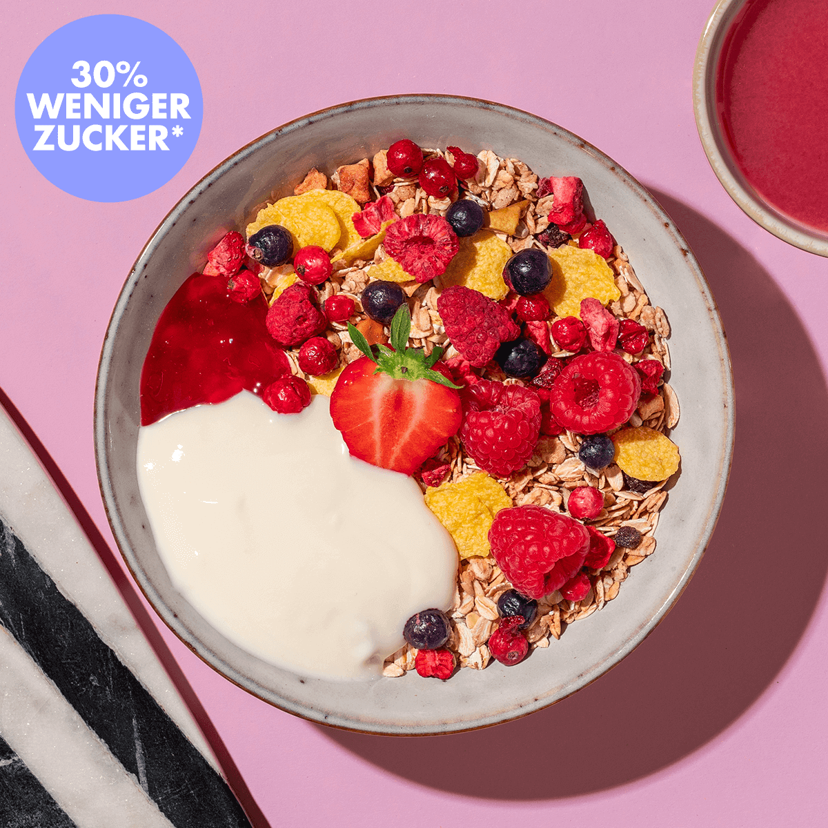 mymuesli Bio Berry Müsli mit Himbeeren, Erdbeeren und Blaubeeren in Schüssel mit frischen Beeren und Joghurt