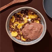 mymuesli Bio Choco Brownie Müsli mit Browniekeksen in Müslischüssel mit Joghurt