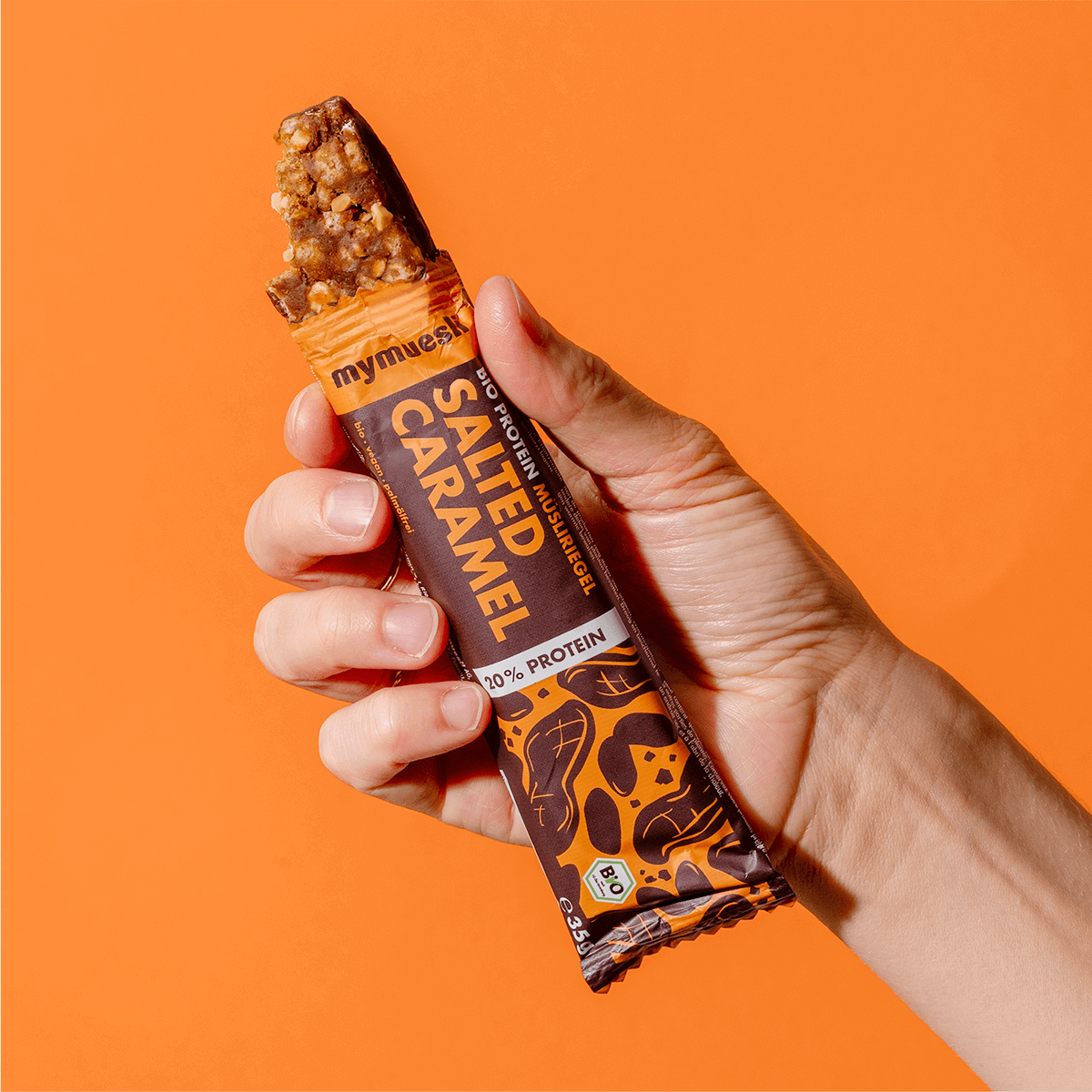 mymuesli Bio Protein Müsliriegel Salted Caramel ausgepackt mit abgebissener Ecke.