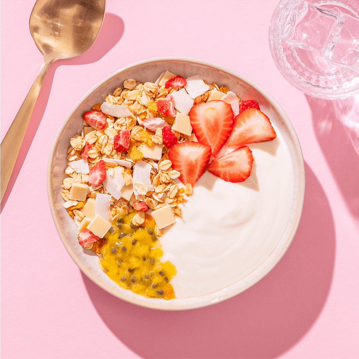mymuesli Bio Sommer Müsli in Schüssel mit Joghurt, frischen Erdbeeren und Passionsfrucht