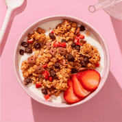 mymuesli Bio Strawberry Choco Crunchy Granola in Schale mit frischen Erdbeeren und Joghurt