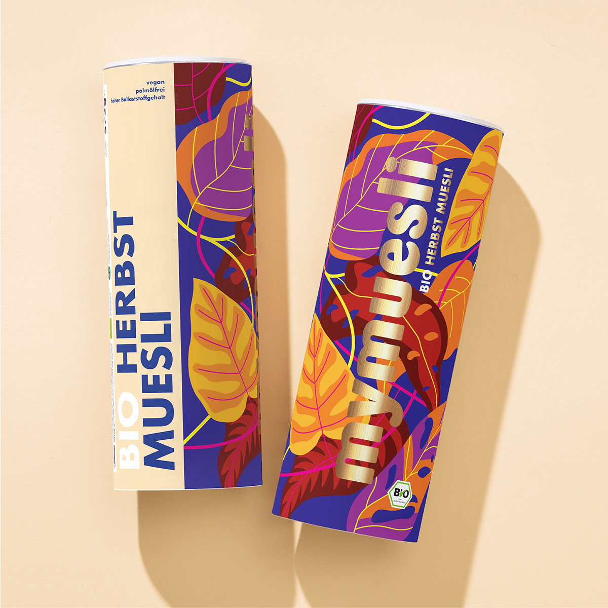 Zwei mymuesli Bio Herbst Müsli Dosen mit herbstlichen Blättern als Design von der Seite