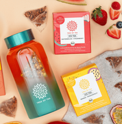 Tree of Tea Ice Tea Starter Set mit einer aufgefüllten Ice Tea bottle in Türkis. Drumherum liegen die enthaltenen Ice Tea Sorten mit frisch aufgeschnittenen Erdbeeren, Wassermelone, Mango und Passionsfrucht.