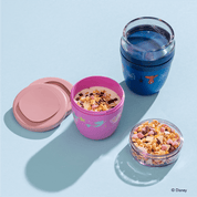 Ein leerer Spiderman Mini 2Go Becher und daneben ein Disney Princess Mini 2Go Becher, der mit Joghurt und Müsli gefüllt wird