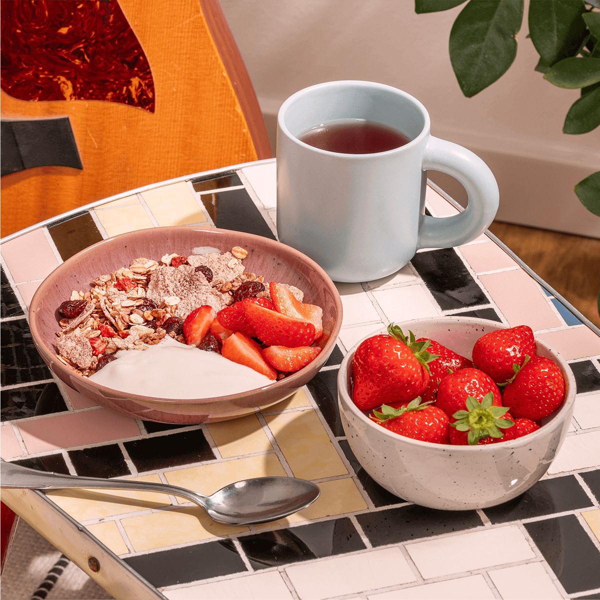 mymuesli Bio Strawberry Acai Granola serviert mit Erdbeeren und Joghurt