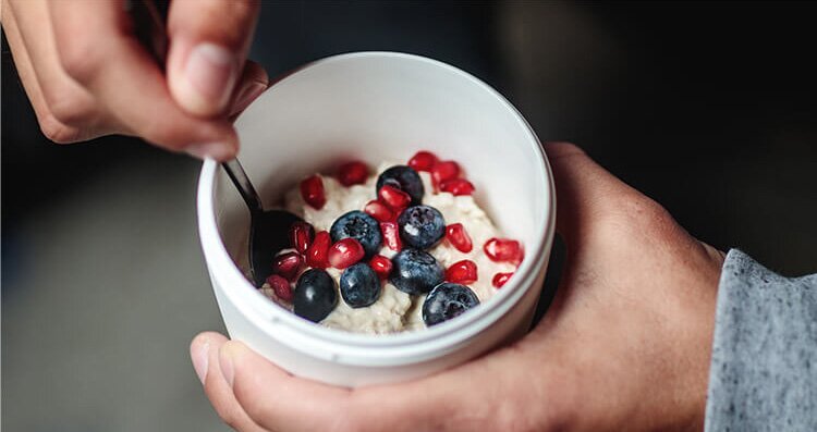 Müsli 2Go Becher mit Porridge und frischen Beeren.